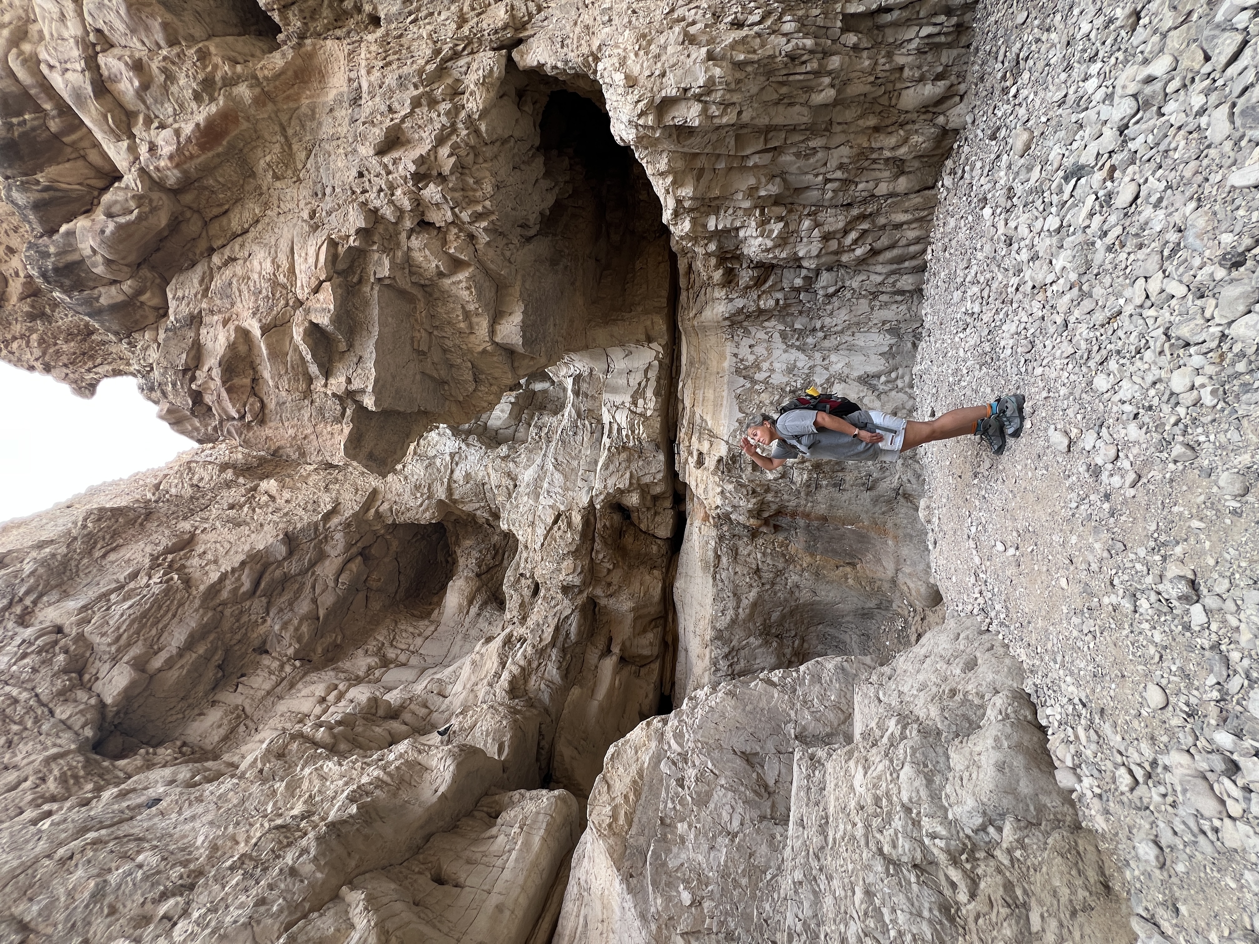 Hiker moving through narrow slot canyon, Og Stream, Dead Sea
